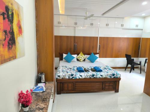 a bedroom with a large bed with blue pillows at Orraica Stays Vajra Rao Luxe in Gundipet