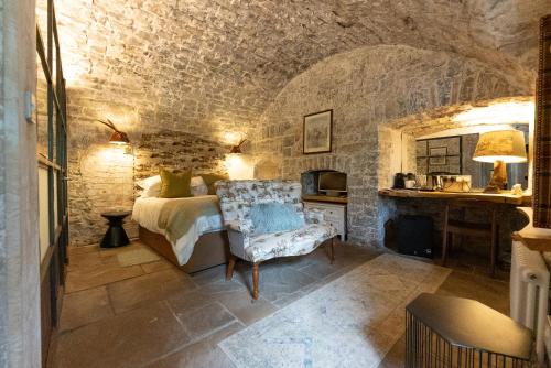 a bedroom with a bed and a chair in a room at Gileston Manor-Self catering in Saint Athans