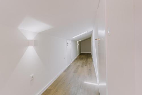 an empty hallway with white walls and wood floors at Belo Encanto in Felgueiras