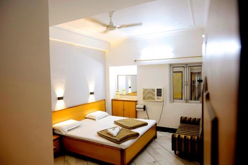 a small bedroom with a bed and a chair at Subhash Hotel in Prayagraj