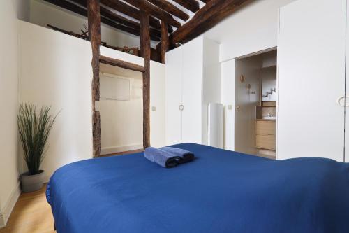- une chambre dotée d'un lit bleu avec un oreiller bleu dans l'établissement Appartement Quartier Panthéon 2 Free Netflix, à Paris