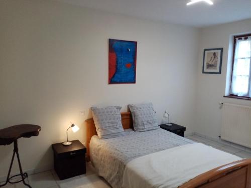 Un dormitorio con una cama y un escritorio y una ventana. en L'atelier, en Ligneyrac