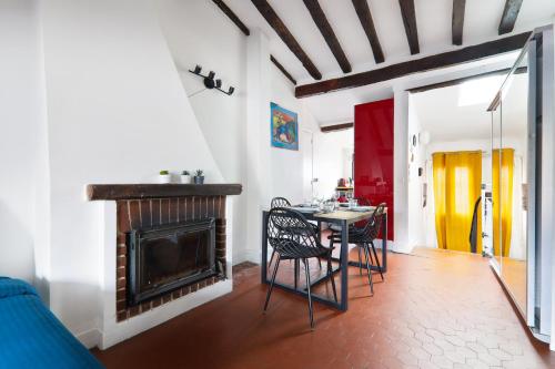 un salon avec une table et une cheminée dans l'établissement Studio Appartement Quartier Saint-Michel Notre-Dame 2 Free Netflix, à Paris