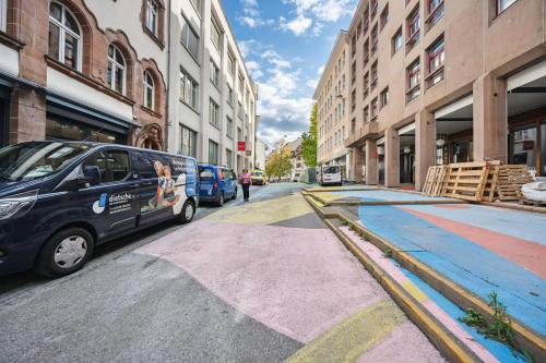 a van parked on the side of a street with buildings at Limehome Basel Münzgasse in Basel