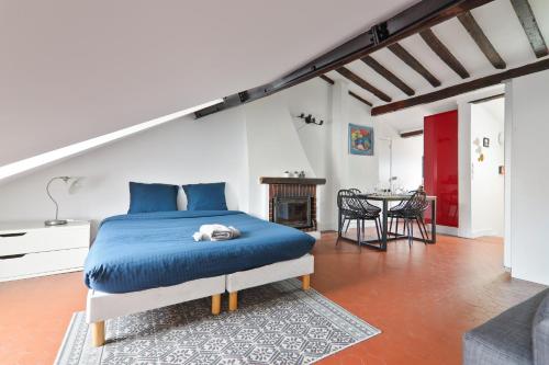 - une chambre avec un lit bleu et une table dans l'établissement Studio Appartement Quartier Saint-Michel Notre-Dame 2 Free Netflix, à Paris