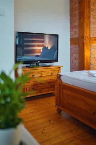 a living room with a television on a wooden dresser at Hotel Na Vyhlídce in Kořenov