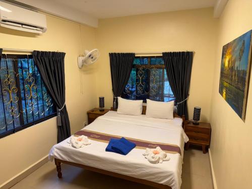 a bedroom with a bed and two windows at Villa Blue Lagoon in Sihanoukville