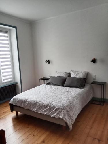 une chambre blanche avec un lit et deux fenêtres dans l'établissement La Ria, à Douarnenez