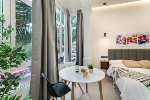 a bedroom with a bed and a table and a bed and a window at Atw Suites Canteras in Las Palmas de Gran Canaria