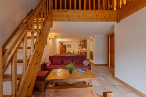 un salon avec un canapé et un escalier en bois dans l'établissement Residence Le Cristal - Grands Montets 19 - Happy Rentals, à Chamonix-Mont-Blanc