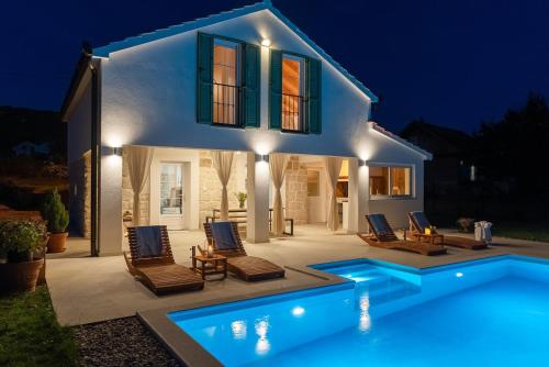 a villa with a swimming pool at night at 2-bedroom Villa Providenca in Bajagić