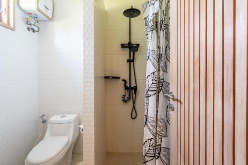 a bathroom with a toilet and a shower curtain at Aura Apartments Ubud in Ubud