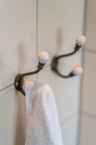 a towel hanging on a towel rack in a shower at Seehotel Lichtenberg in Lichtenberg