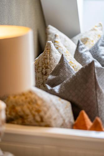 a pile of pillows on a bed with a candle at Seehotel Lichtenberg in Lichtenberg