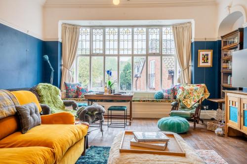 a living room with a yellow couch and a large window at 7 Arndale Court in York
