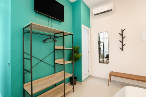 a room with a green wall and a book shelf at Atw Suites Canteras in Las Palmas de Gran Canaria