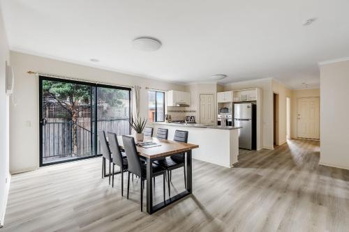 墨尔本Heart of McKinnon Units by Ready Set Host的配有桌椅的厨房和餐厅