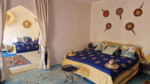 a bedroom with a bed with hats on the wall at Les Trois Paons in Taroudant