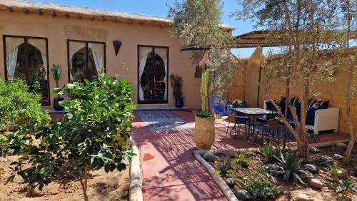 a house with a patio with a table and chairs at Les Trois Paons in Taroudant