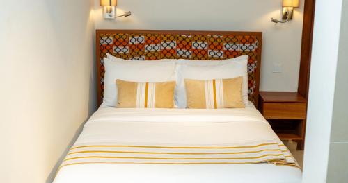 a bedroom with a large bed with a headboard at Château NaNa Willine in Accra