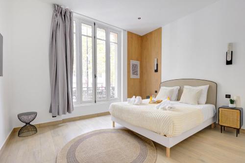 une chambre avec un lit et une grande fenêtre dans l'établissement Bluestay 287 - Superbe appartement à Paris 17, à Paris