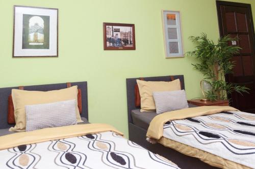two beds sitting next to each other in a room at Red Clay Apartments City Club in Belgrade