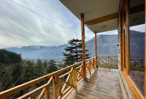 a balcony of a house with a view of mountains at Kutumb Homestay Naggar in Nagar