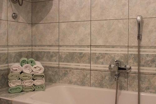 a bathroom with a tub with a shower and towels at House Toncica in Dol