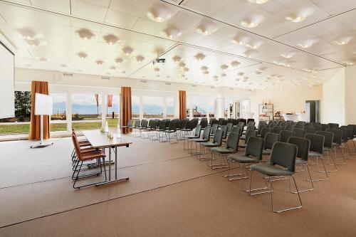 a large room with chairs and tables and windows at Rigi Kaltbad Swiss Quality Hotel in Rigi Kaltbad
