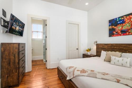 a bedroom with a large bed and white walls at Fabulous Cottages with City Views in New Orleans