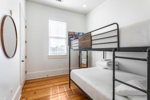 a bedroom with two bunk beds and a mirror at Fabulous Cottages with City Views in New Orleans