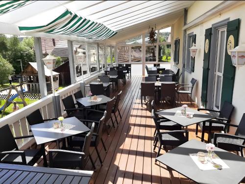 a restaurant with tables and chairs on a deck at Gasthof Adler in Ebenweiler