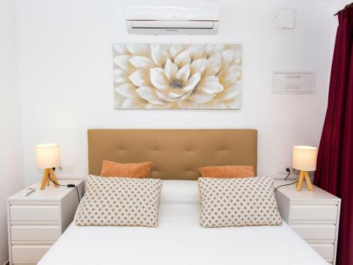 a bedroom with a large bed with two lamps at Casa Marineta III in Denia