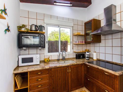 a kitchen with a sink and a microwave at Casa Marineta III in Denia