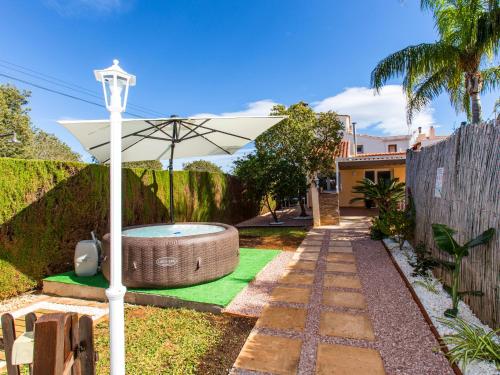 a backyard with a hot tub and an umbrella at Casa Marineta III in Denia