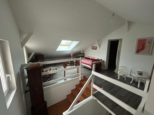 Cette chambre mansardée dispose d'un escalier et d'un lit. dans l'établissement La Soyotte, à La Veuve