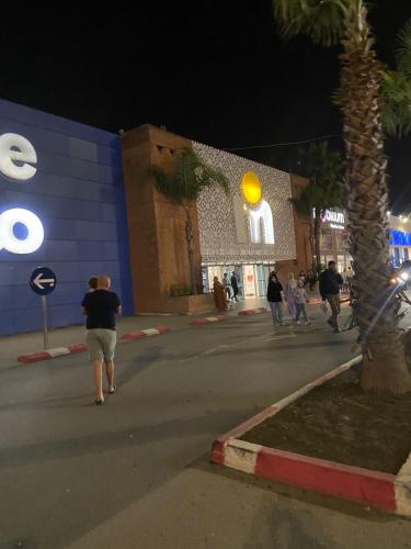 a group of people walking down a street at night at Swim and rest in Beni Touzine