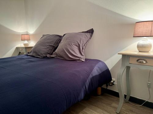 - un lit avec deux oreillers et une table avec deux lampes dans l'établissement Provence, à Digne-Les-Bains