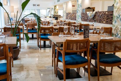 a dining room with wooden tables and chairs at Hotel ROC Illetas & SPA in Illetas