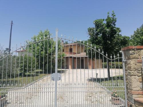a white gate in front of a building at Il boschetto da Michael -nocciolo in Badia Al Pino