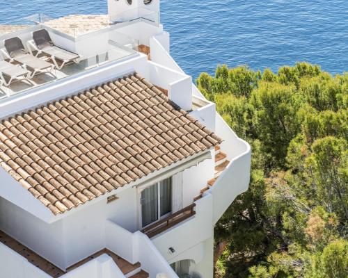 a white house with chairs on the roof at Hotel ROC Illetas & SPA in Illetas