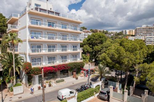 an apartment building on a city street with trees at Hotel ROC Illetas & SPA in Illetas