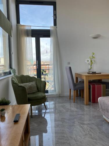 a living room with a green chair and a table at Swansea Bay, Marina, Swansea Arena, Beach & City in Swansea