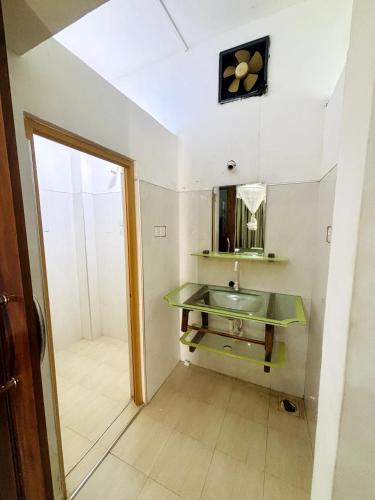 a bathroom with a green sink and a mirror at Nihal Bay View in Matara