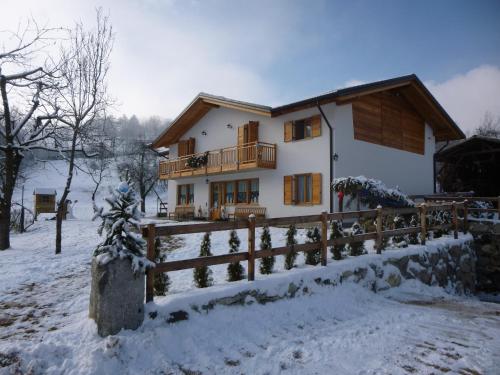 une maison dans la neige avec une clôture dans l'établissement Agriturismo Fattoria Dalcastagnè, à Torcegno