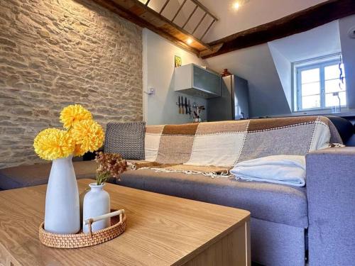 a living room with a couch and a table with flowers at Le Mignon de Chenôve in Chenôve