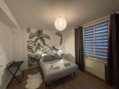 a bedroom with a bed and a palm tree mural at Jolie Maison de Ville in Saint-Aignan