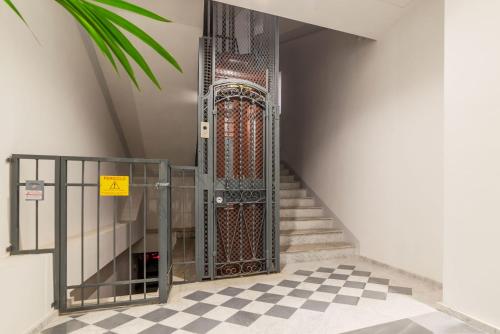 an open gate in a stairway with a checkered floor at JOIVY Cavour 238 in Rome