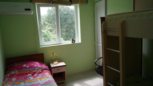 a bedroom with a bunk bed and a window at TJ Guest House in Makhinjauri