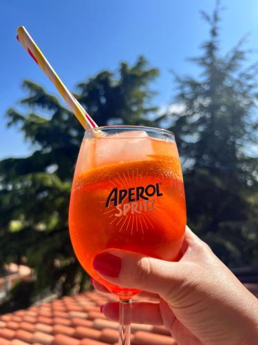 a person holding up a glass of orange liquid at Sicily in Love - Rooms and Apartment - Pedara Catania Etna in Pedara